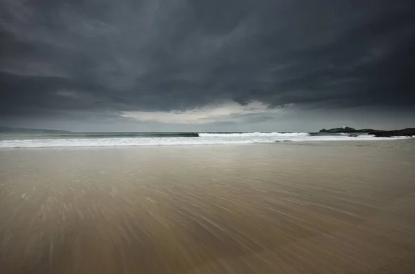 Piękne Ujęcie Piaszczystego Morza Falującym Morzem Tle Pod Zachmurzonym Niebem — Zdjęcie stockowe