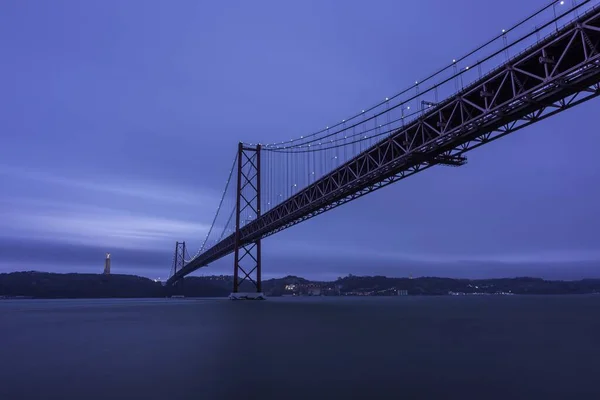 Den Abril Bridge Över Floden Tagus Omgiven Kullar Och Ljus — Stockfoto