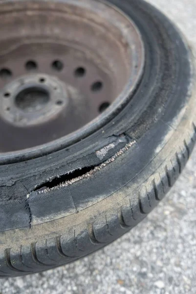 A selective focus shot of a torn tire with a blurred background