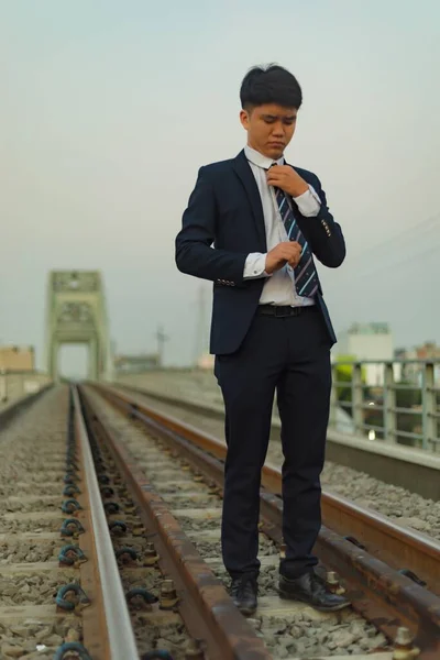 Ein Junger Asiatischer Geschäftsmann Steht Inmitten Einer Eisenbahn Und Fixiert — Stockfoto