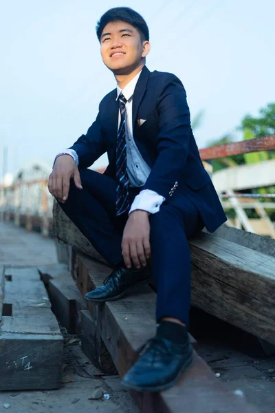 Ein Junger Asiatischer Mann Anzug Sitzt Auf Einem Holzstapel Mit — Stockfoto