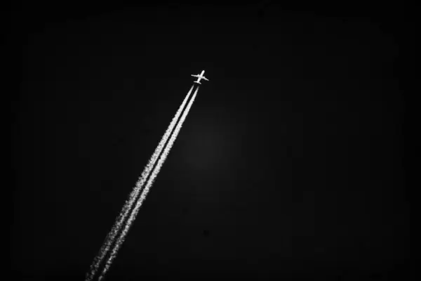 一架喷气式飞机在漆黑的天空中飞扬着浓烟 — 图库照片