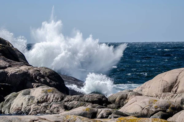 巨大な岩の層の近くに飛び散る海の波の美しいショット — ストック写真