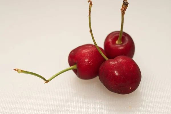 Primer Plano Tres Cerezas Dulces Sobre Fondo Claro — Foto de Stock