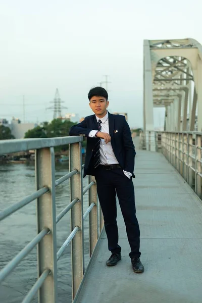 Ένας Νεαρός Ασιάτης Κοστούμι Που Στηρίζεται Κάγκελα Γέφυρας — Φωτογραφία Αρχείου