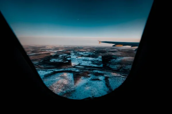 Красивый Снимок Крыла Самолета Через Окно Над Заснеженным Ландшафтом — стоковое фото