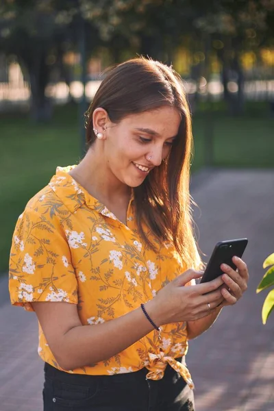 Plan Vertical Une Jeune Fille Chemise Jaune Regardant Son Téléphone — Photo