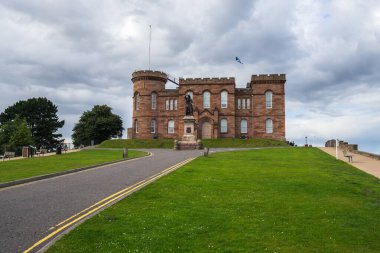 A long shot of the famous Inverness Castle in Scotland under a cloudy sky clipart