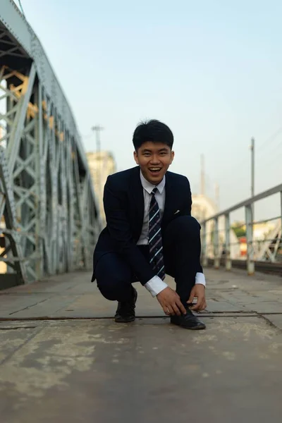 Ung Asiatisk Affärsman Knyter Sitt Skosnöre Med Ett Brett Leende — Stockfoto