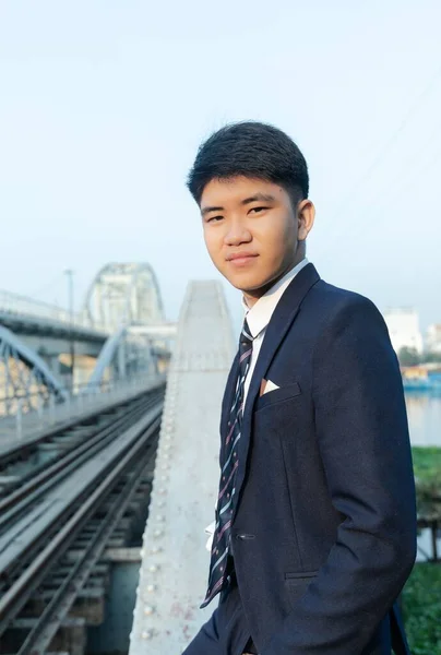 Ένας Σίγουρος Νεαρός Ασιάτης Κοστούμι Γέρνει Μια Γέφυρα — Φωτογραφία Αρχείου