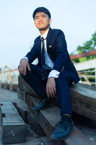 Ein Junger Asiatischer Mann Anzug Sitzt Auf Einem Haufen Baumstämme — Stockfoto