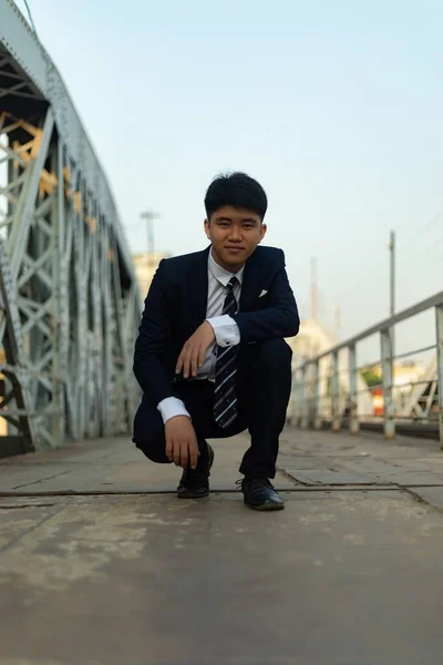 Ein Junger Asiatischer Mann Anzug Hockt Auf Einer Brücke — Stockfoto