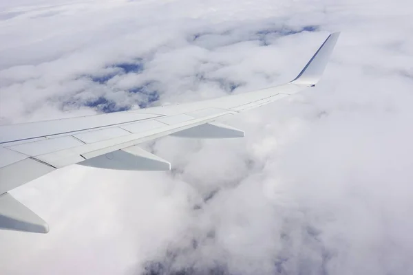 飛行機の窓からの雲と飛行機の翼でいっぱいの空の美しいショット — ストック写真