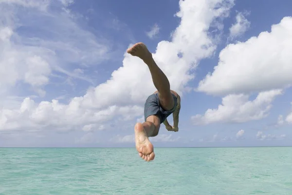 Ein Junger Mann Blauen Shorts Springt Unter Blauem Himmel Ins — Stockfoto