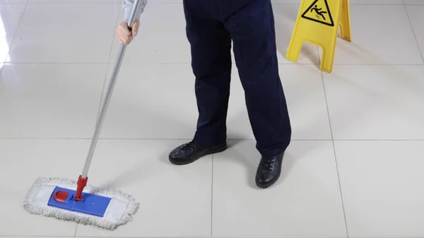 Ein Mann Reinigt Den Boden Mit Einem Nassen Bodenschild Der — Stockfoto