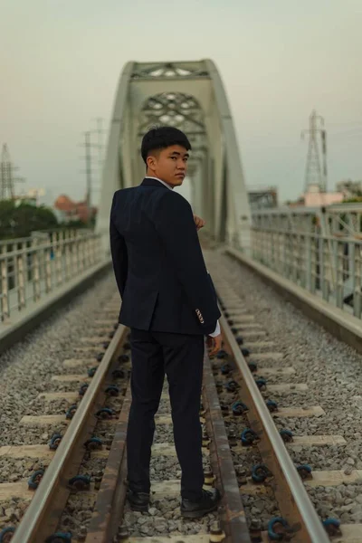 Sebevědomý Mladý Asiat Obleku Stojící Uprostřed Železnice Ohlížející — Stock fotografie