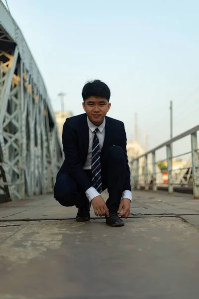 Ένας Νεαρός Ασιάτης Επιχειρηματίας Δένει Κορδόνια Του Μια Γέφυρα — Φωτογραφία Αρχείου