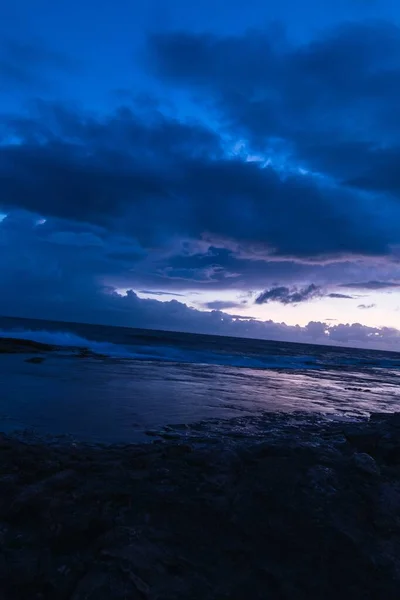 海面上乌云密布的落日的垂直镜头 — 图库照片
