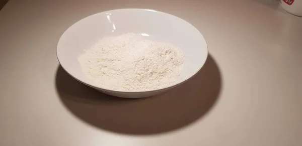 テーブルの上の白い皿の上の小麦粉 — ストック写真