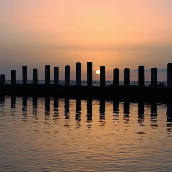 Vista Sul Tramonto Con Pali Verticali Sulla Riva Riflessi Acqua — Foto Stock