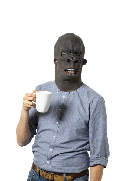 一个戴着黑色愤怒面具的男人拿着一个白色杯子的竖直照片 — 图库照片
