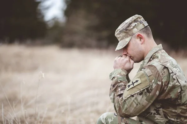 一个年轻士兵在田野里祈祷的浅浅的镜头 — 图库照片