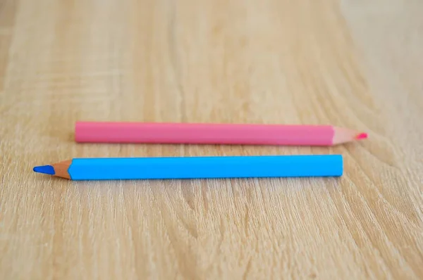 Zbliżenie Ujęcie Dwóch Niebieskich Różowych Ołówków Rysunkowych Drewnianej Powierzchni — Zdjęcie stockowe