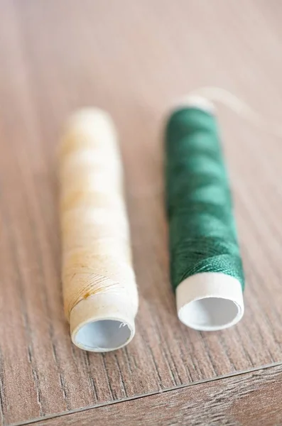 Closeup Shot White Green Sewing Threads Wooden Surface — Stock Photo, Image
