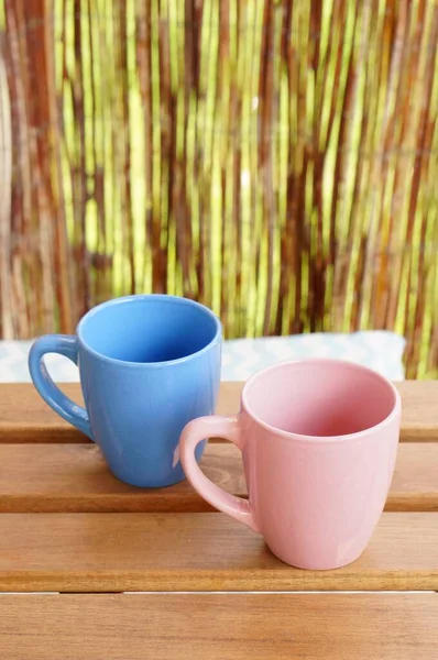 Ein Blauer Und Ein Pinkfarbener Becher Auf Einem Holztisch — Stockfoto