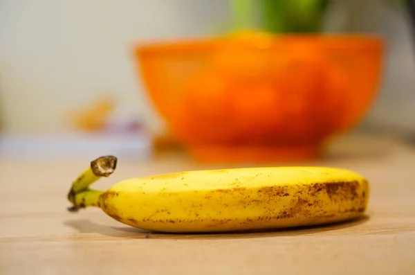 Zbliżenie Ujęcia Banana Drewnianym Stole Zamazanym Tłem — Zdjęcie stockowe