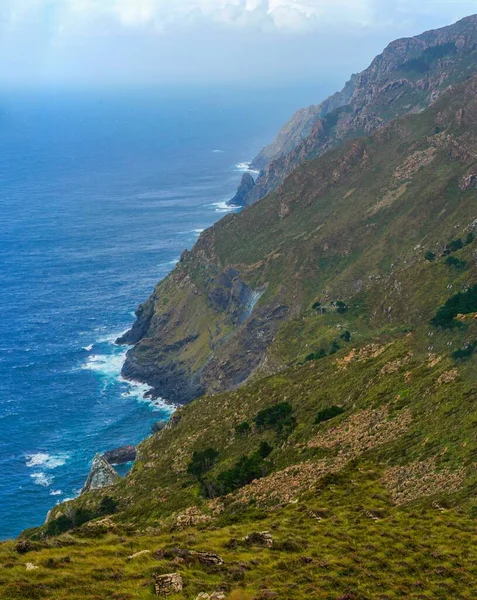 Foto Verticale Una Scogliera Ricoperta Verde Circondata Dal Mare Sotto — Foto Stock