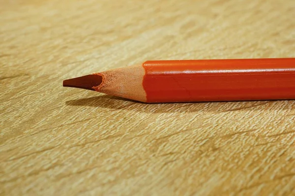 Zbliżenie Ujęcia Ciemnopomarańczowego Rysunku Ołówek Drewnianej Powierzchni — Zdjęcie stockowe