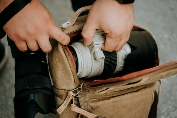 Ένας Φωτογράφος Βγάζει Ένα Λευκό Φακό Από Μια Τσάντα Κάμερας — Φωτογραφία Αρχείου