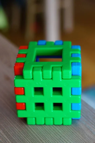 Вертикальний Крупним Планом Знімок Пластикового Кубика Іграшки Дерев Яній Поверхні — стокове фото