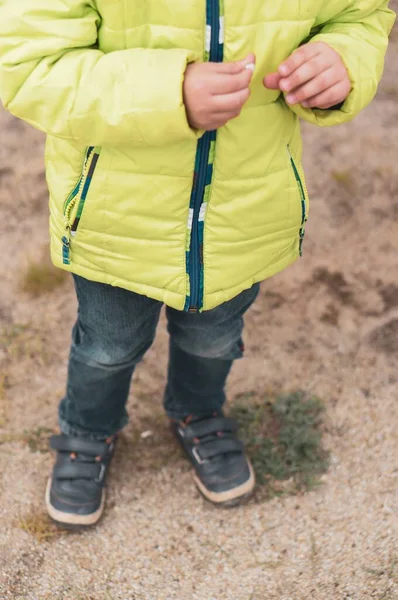 Egy Függőleges Felvétel Egy Sárga Kabátos Gyerekről Aki Homályos Háttérrel — Stock Fotó
