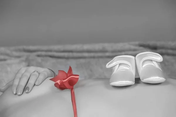 一张黑白照片 拍摄的是一个身披红线 头戴童鞋的孕妇 — 图库照片