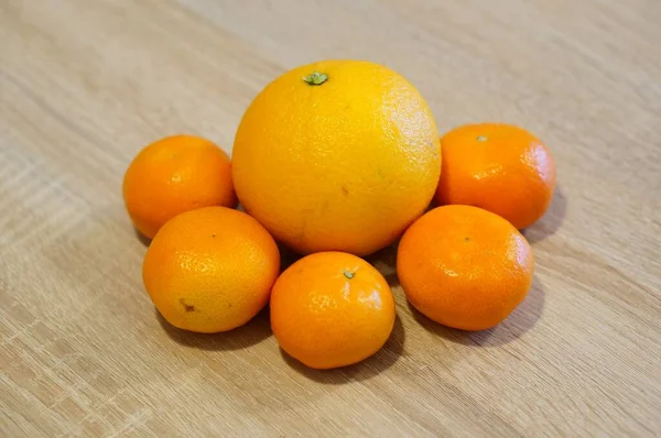 Tahta Bir Yüzey Üzerinde Bir Portakalın Etrafındaki Beş Mandalinanın Yakın — Stok fotoğraf