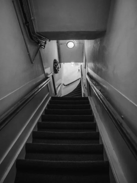 一道狭长楼梯的低角度拍摄的照片 它以黑白相间的方式爬上一座建筑物 — 图库照片