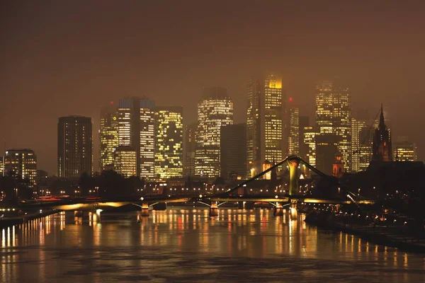 夜幕降临时 一座以城市建筑为背景的水上桥的美丽照片 — 图库照片