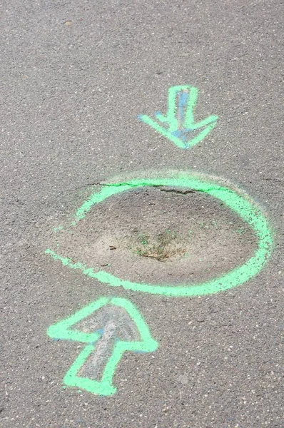 地面に描かれた円を指している2本の矢の垂直ショット — ストック写真