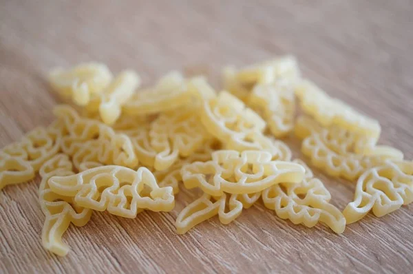 Closeup Shot Soup Noodles Dinosaur Shapes Wooden Surface — Stock Photo, Image