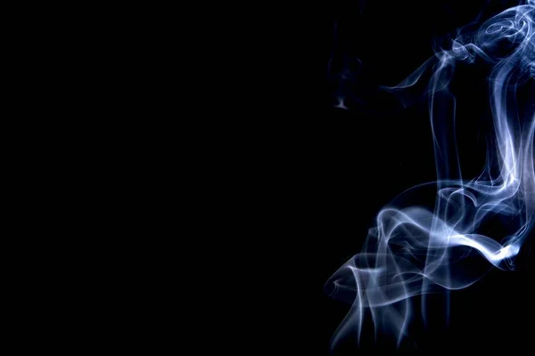 黒い背景に青い煙が渦巻いている — ストック写真
