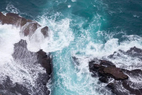 一个美丽的海浪在巨大的岩层附近飞溅 — 图库照片