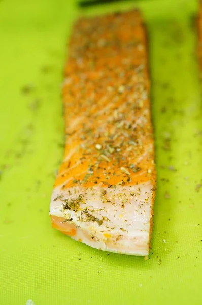 緑のまな板の上にハーブと新鮮なサーモンの肉の垂直閉鎖ショット — ストック写真