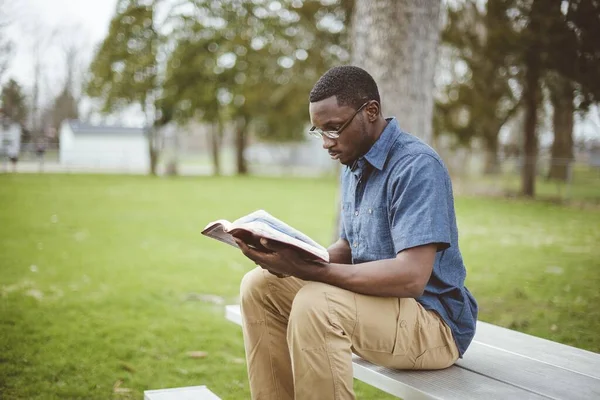 Jovem Afro Americano Sentado Banco Lendo Bíblia — Fotografia de Stock