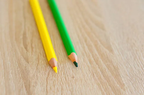 Zbliżenie Ujęcie Dwóch Żółtych Zielonych Ołówków Rysunkowych Drewnianej Powierzchni — Zdjęcie stockowe