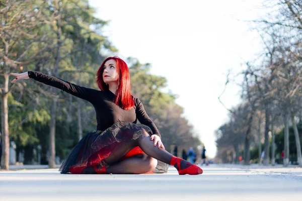 一位漂亮的红头发芭蕾舞演员 穿着橙色尖尖的鞋子 优雅地在公园里跳舞 — 图库照片