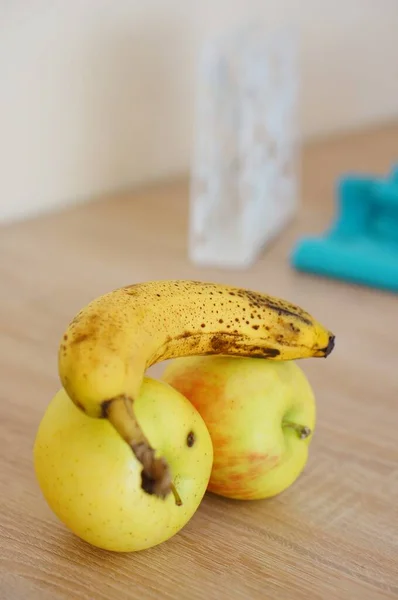 Pionowe Zbliżenie Shota Dojrzałego Banana Dwóch Jabłkach Drewnianej Powierzchni — Zdjęcie stockowe