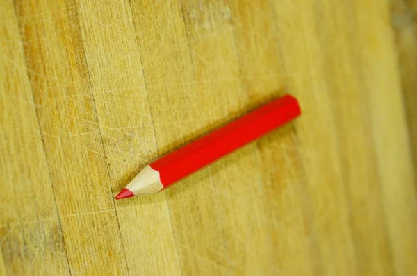 木製の表面に赤い鉛筆の垂直クローズアップショット — ストック写真