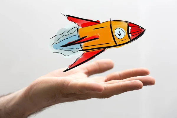 Beyaz Arka Planda Turuncu Bir Roket Simgesi Tutan Bir Adam — Stok fotoğraf